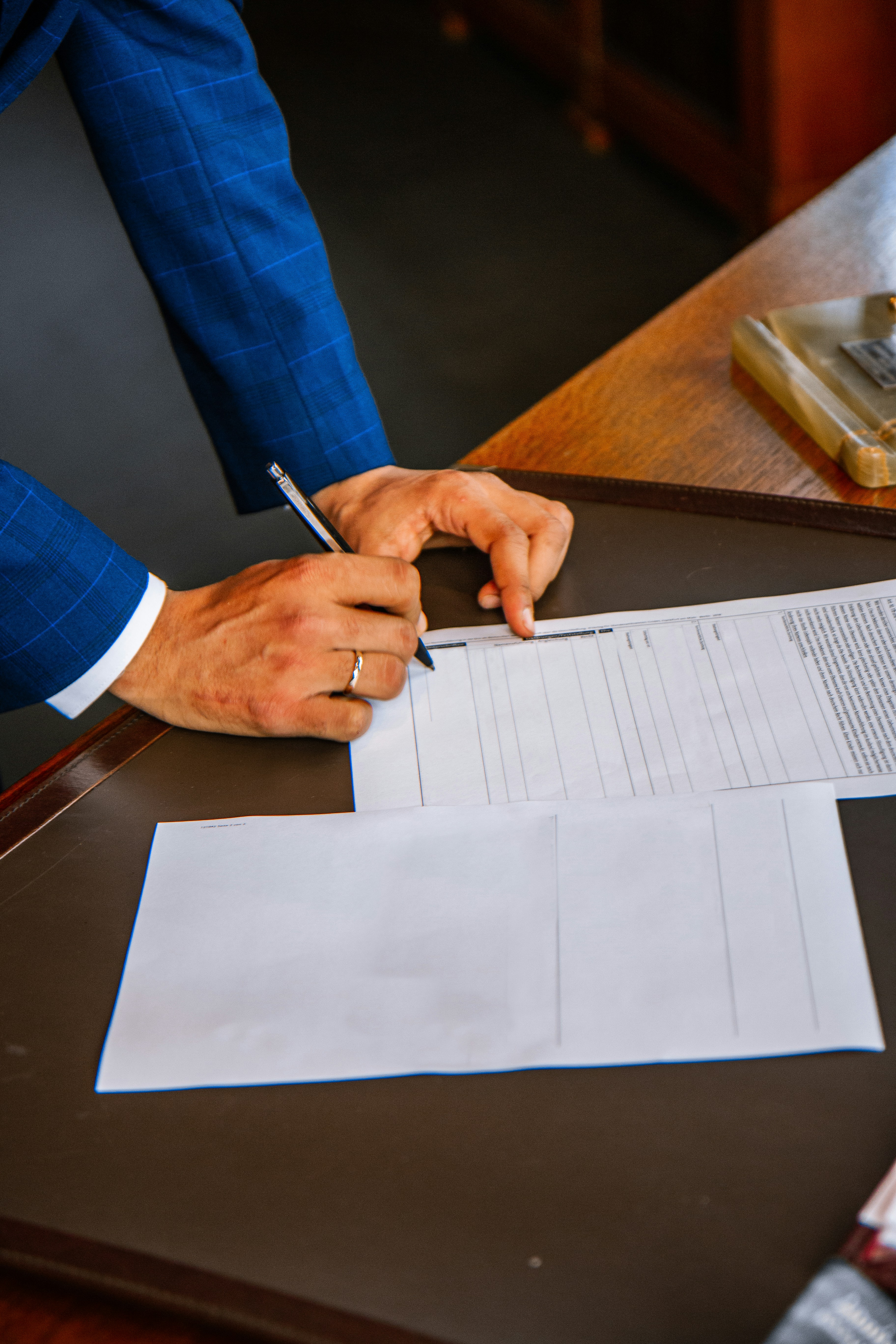 Personne en complet signant un formulaire de proposition d’assurance